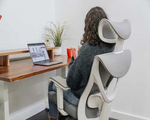 Person adjusting their chair height at a home office setup